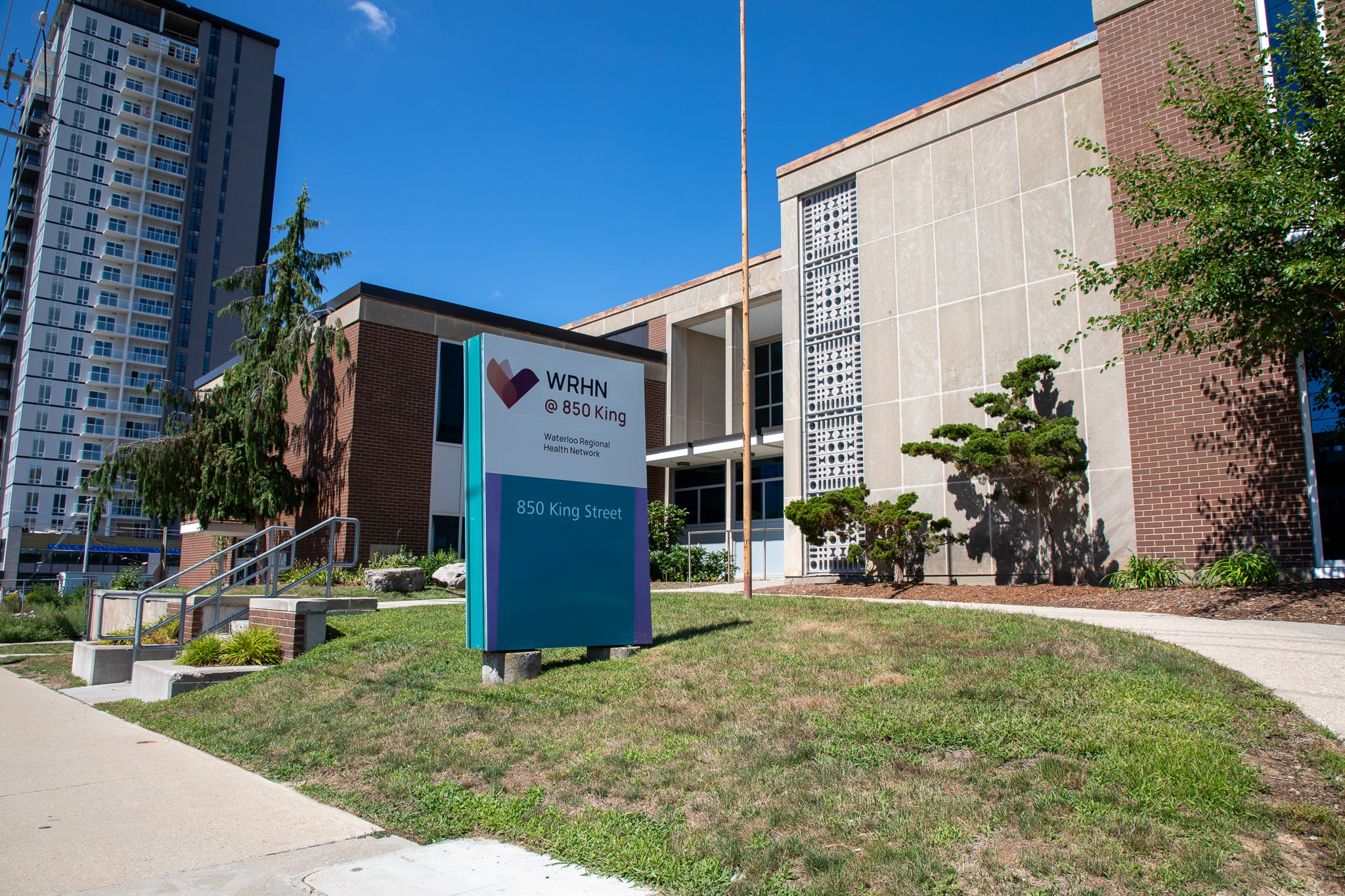 A modern building with a sign reading "WRHN @ 850 King, 850 King Street" on a sunny day.